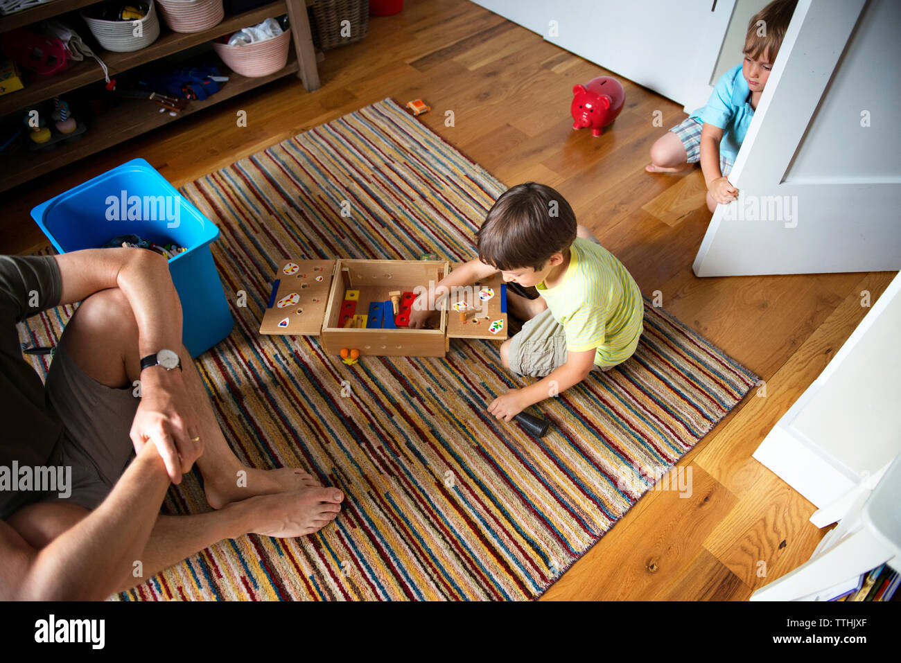 High angle view of father sitting by boys playing at home Stock Photo