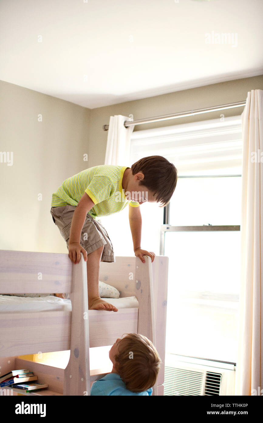 Brothers playing on bunkbed at home Stock Photo