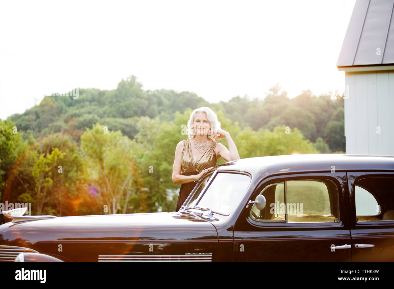 Portrait Of Happy Senior Woman Standing By Vintage Car Against Trees Stock Photo Alamy