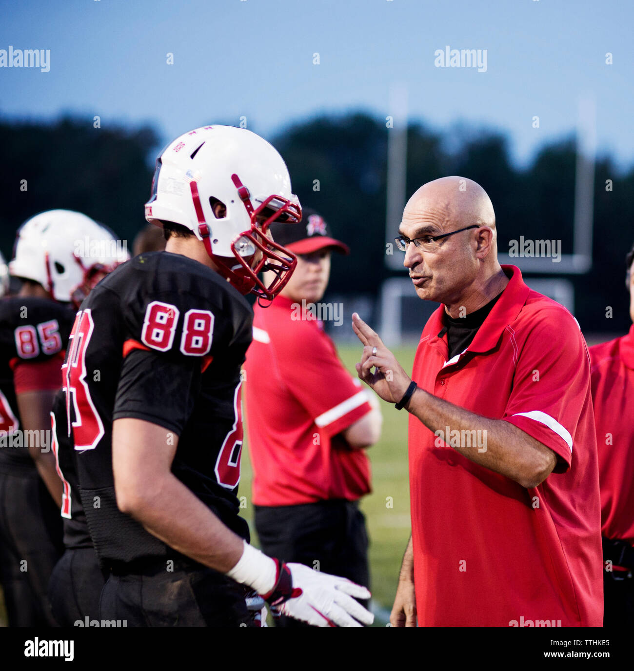 Coach explaining American football  players on field Stock Photo