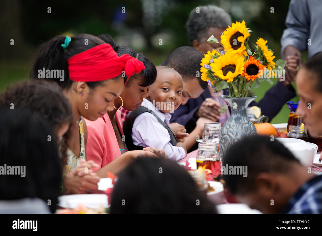 Portrait of smiling boy sitting with family and friends at table while having food Stock Photo
