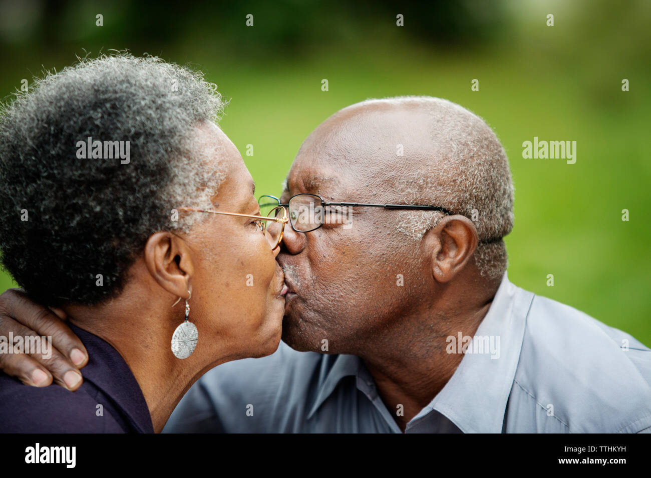 Close-up of romantic senior couple kissing in backyard Stock Photo