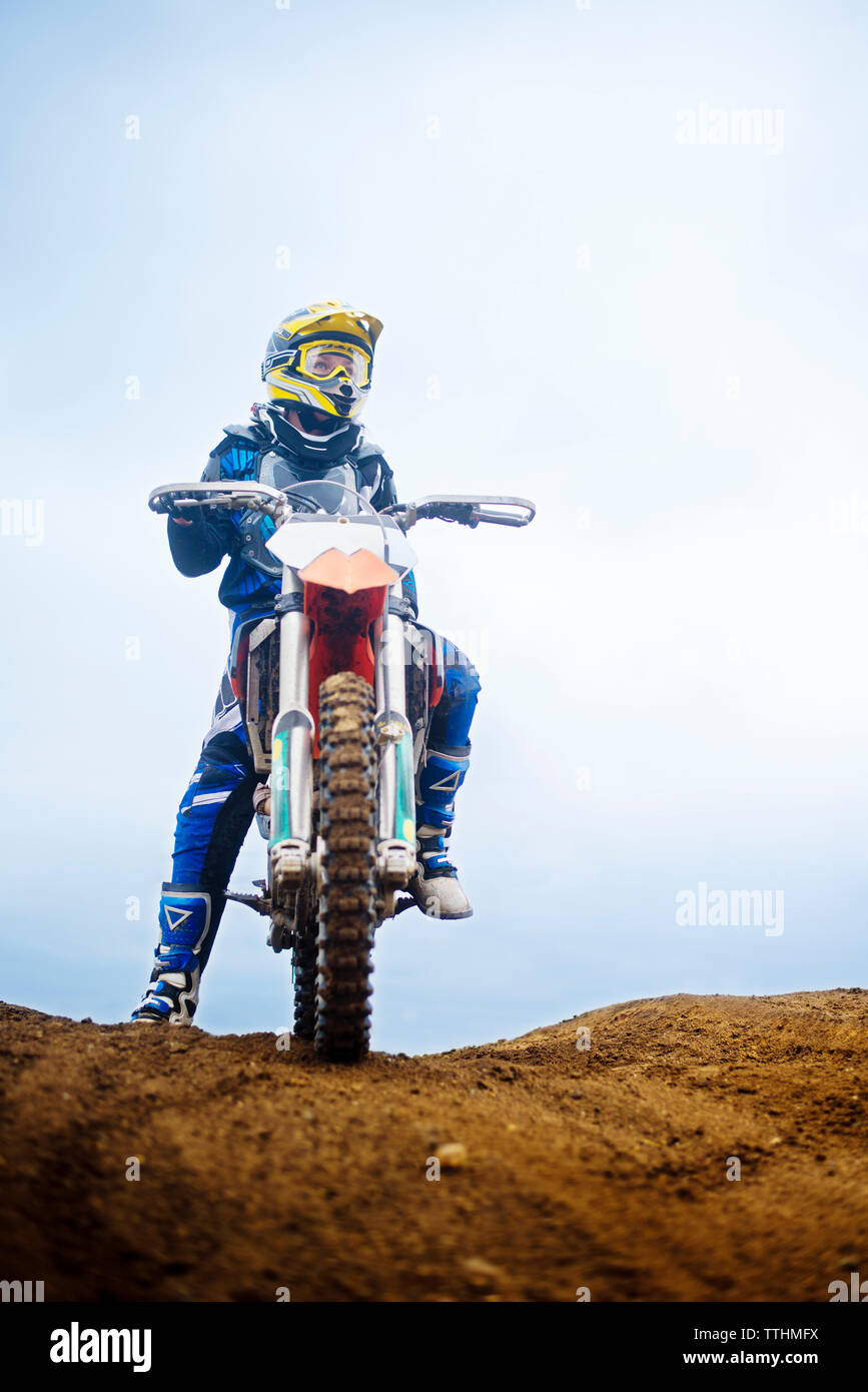 Low angle view of woman riding motorcycle against sky Stock Photo