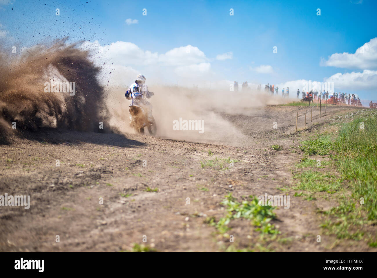 Rear view of man riding motorcycle on dirt road against sky Stock Photo