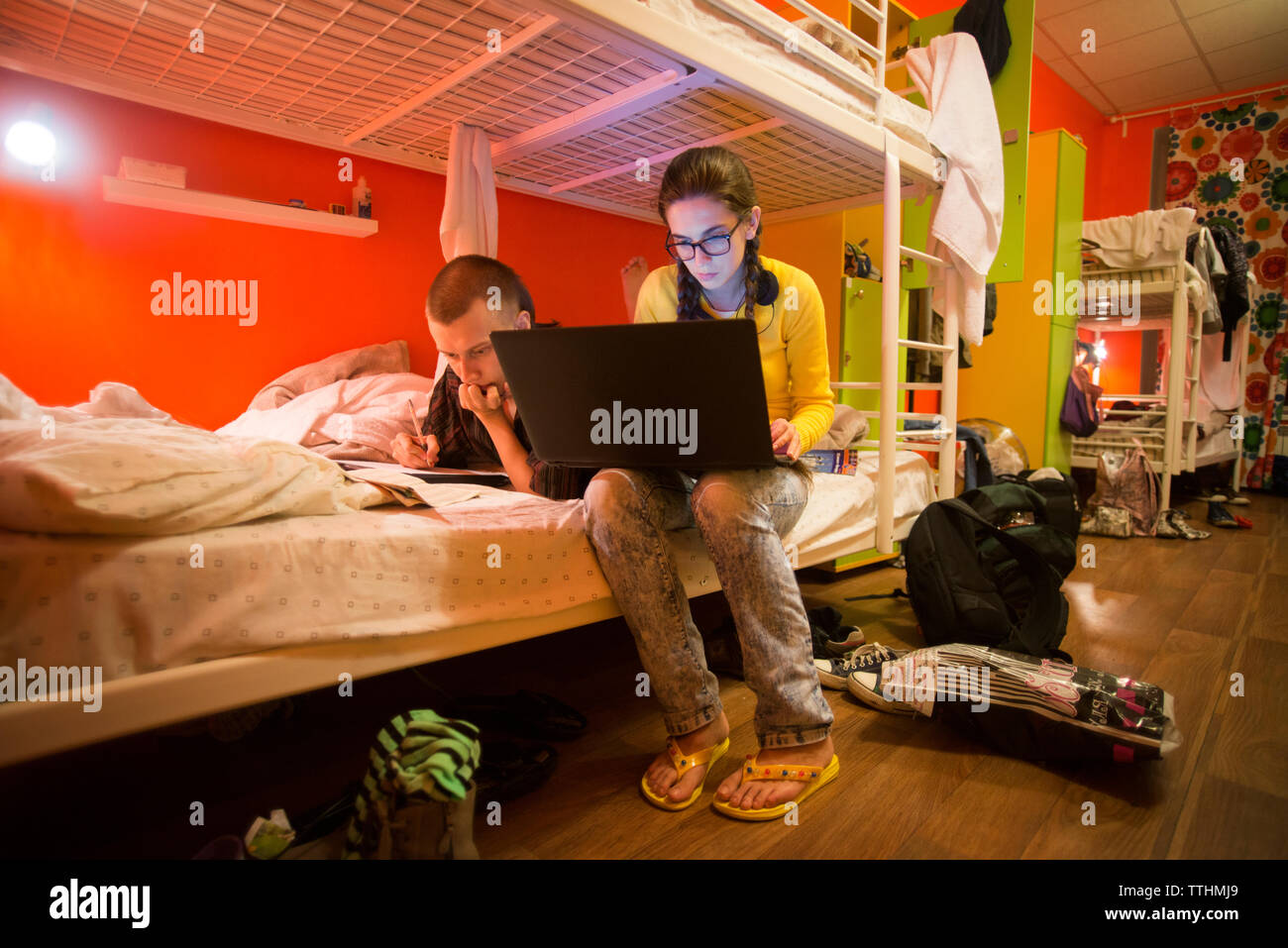 Serious friends studying on bunkbed at home Stock Photo