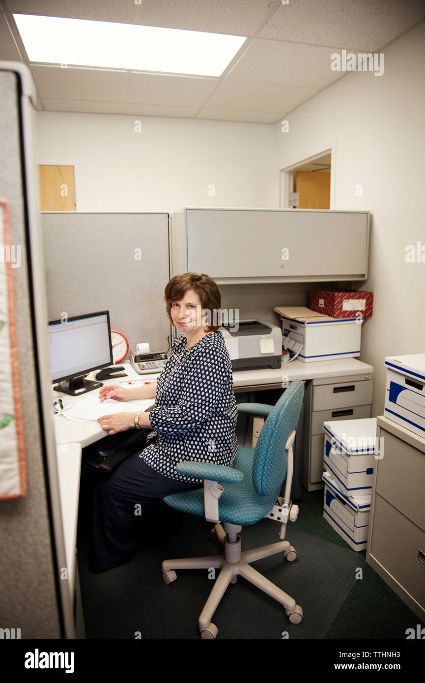 Happy mature woman working at desk in office Stock Photo - Alamy