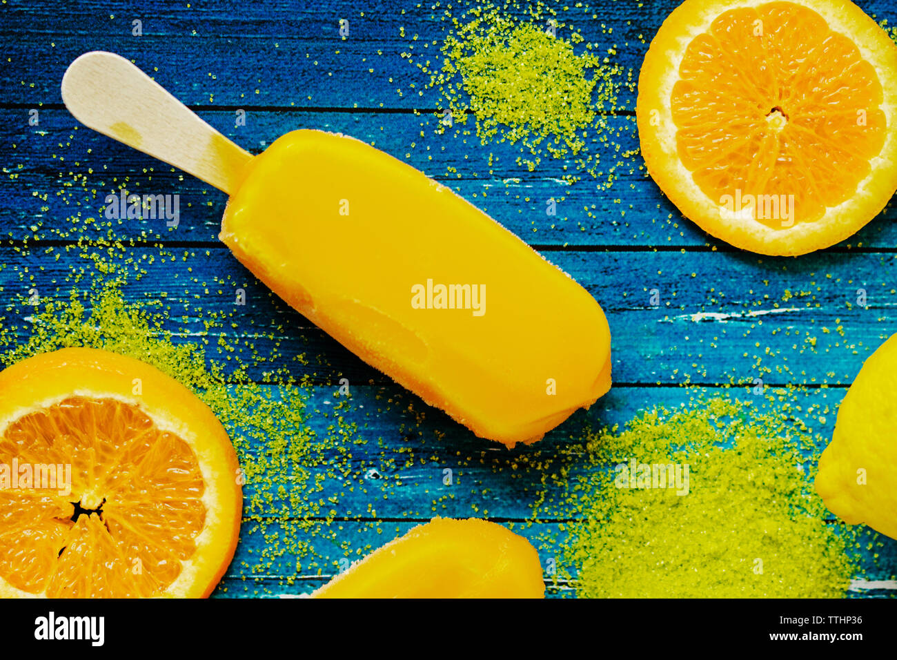 Overhead view of popsicle by orange slices and powder on table Stock Photo
