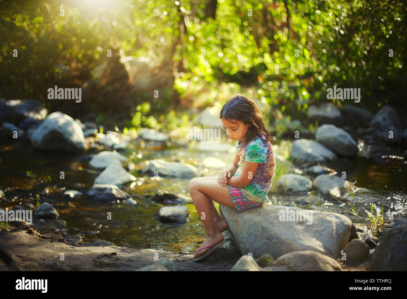 Thoughtful girl sitting on rock hi-res stock photography and images - Alamy