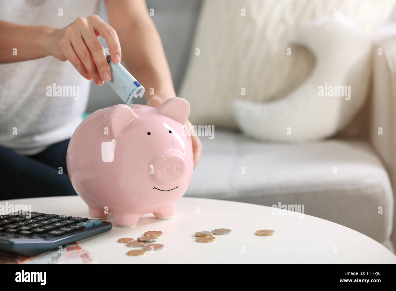 Hand putting money piggy bank hi-res stock photography and images - Alamy