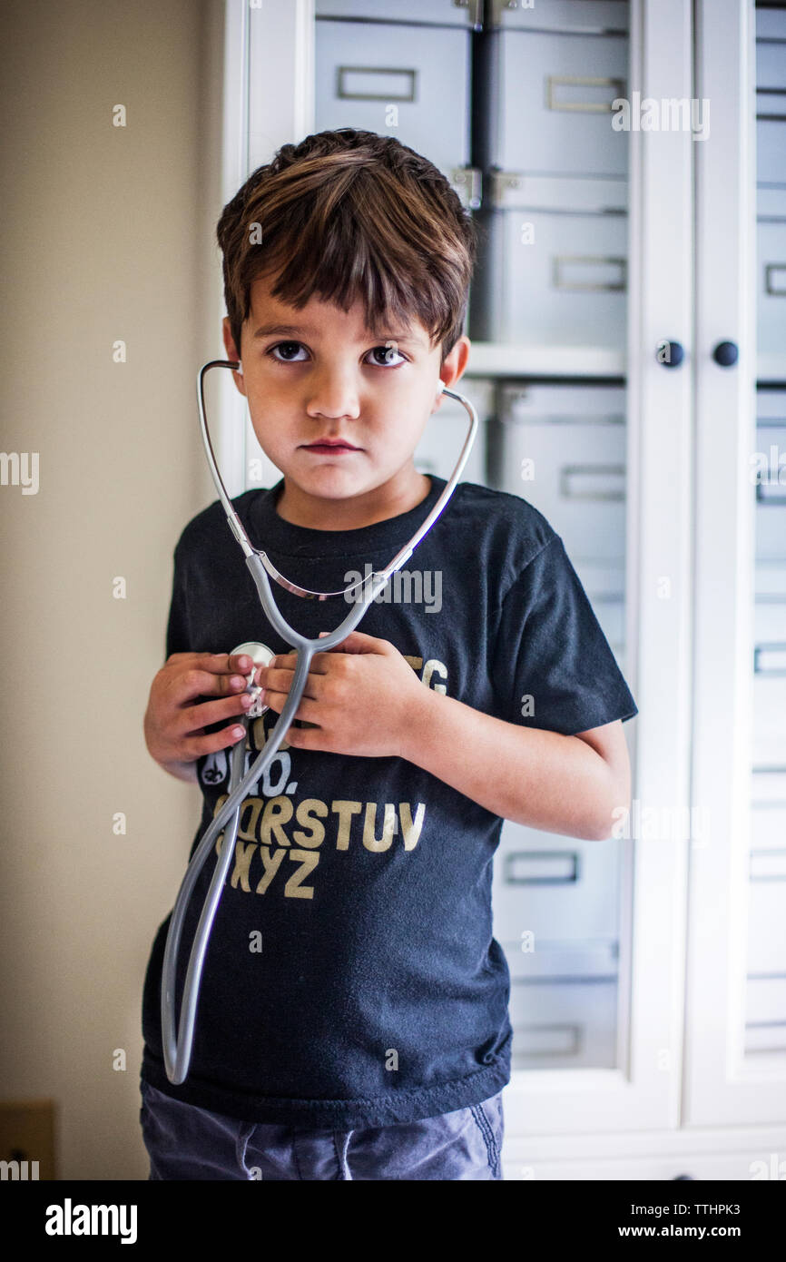Boy looking away while using stethoscope at home Stock Photo Alamy