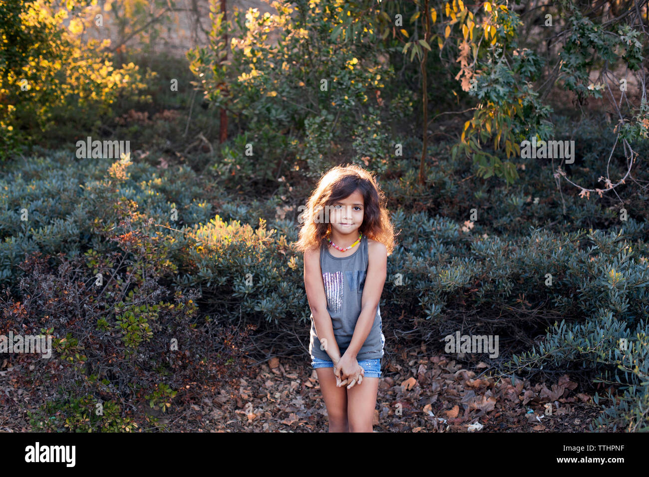 Portrait of girl standing at forest Stock Photo