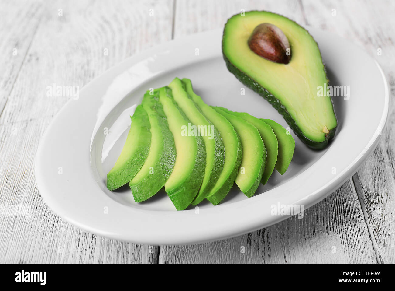 Slices of fresh avocado on plate closeup Stock Photo - Alamy
