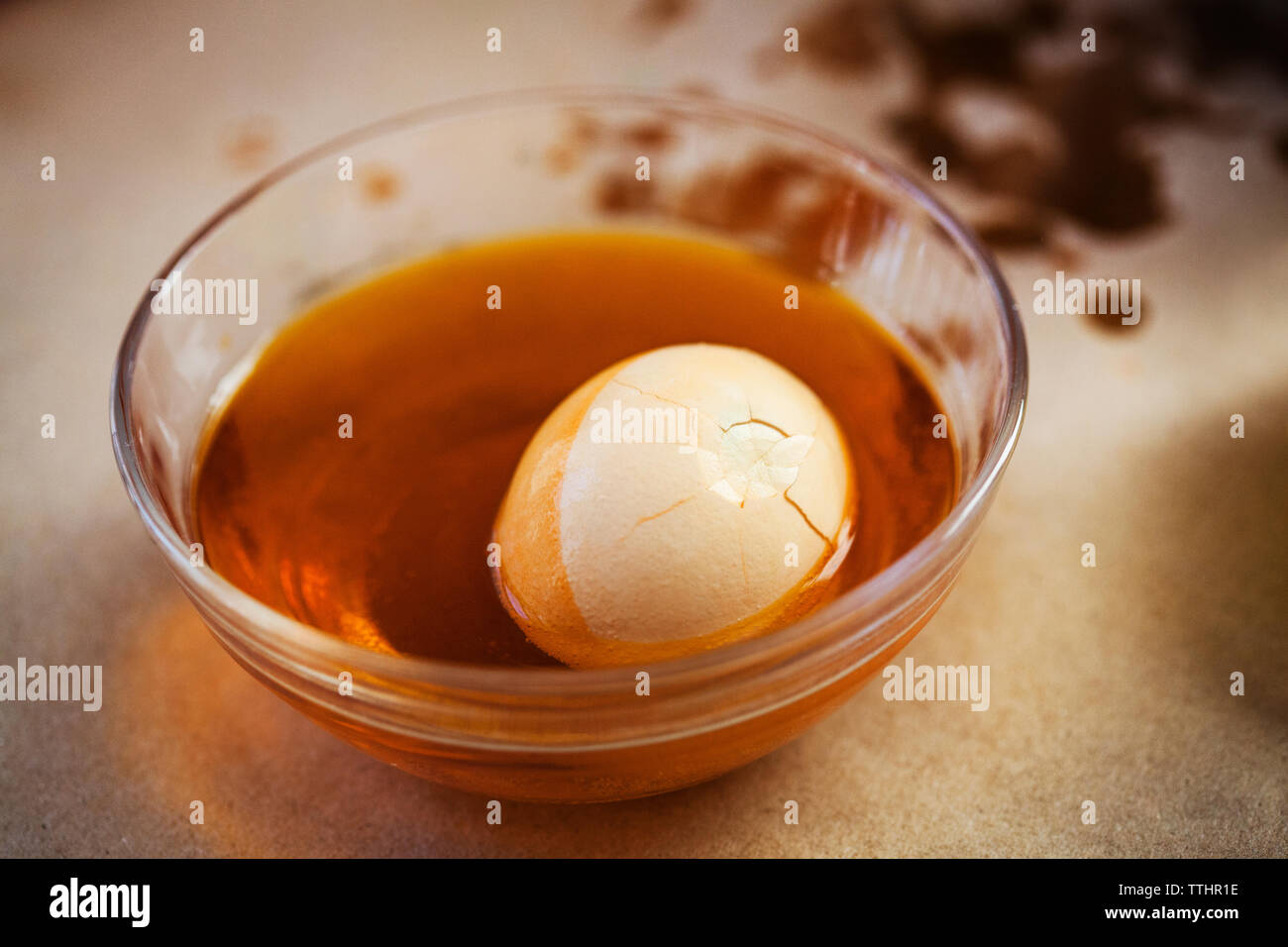 High angle view of cracked easter egg in food coloring bowl Stock Photo