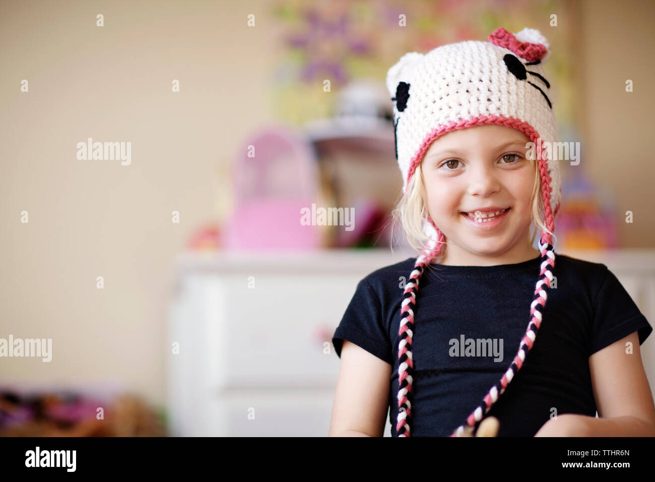 Portrait of smiling girl wearing knit hat at home Stock Photo - Alamy