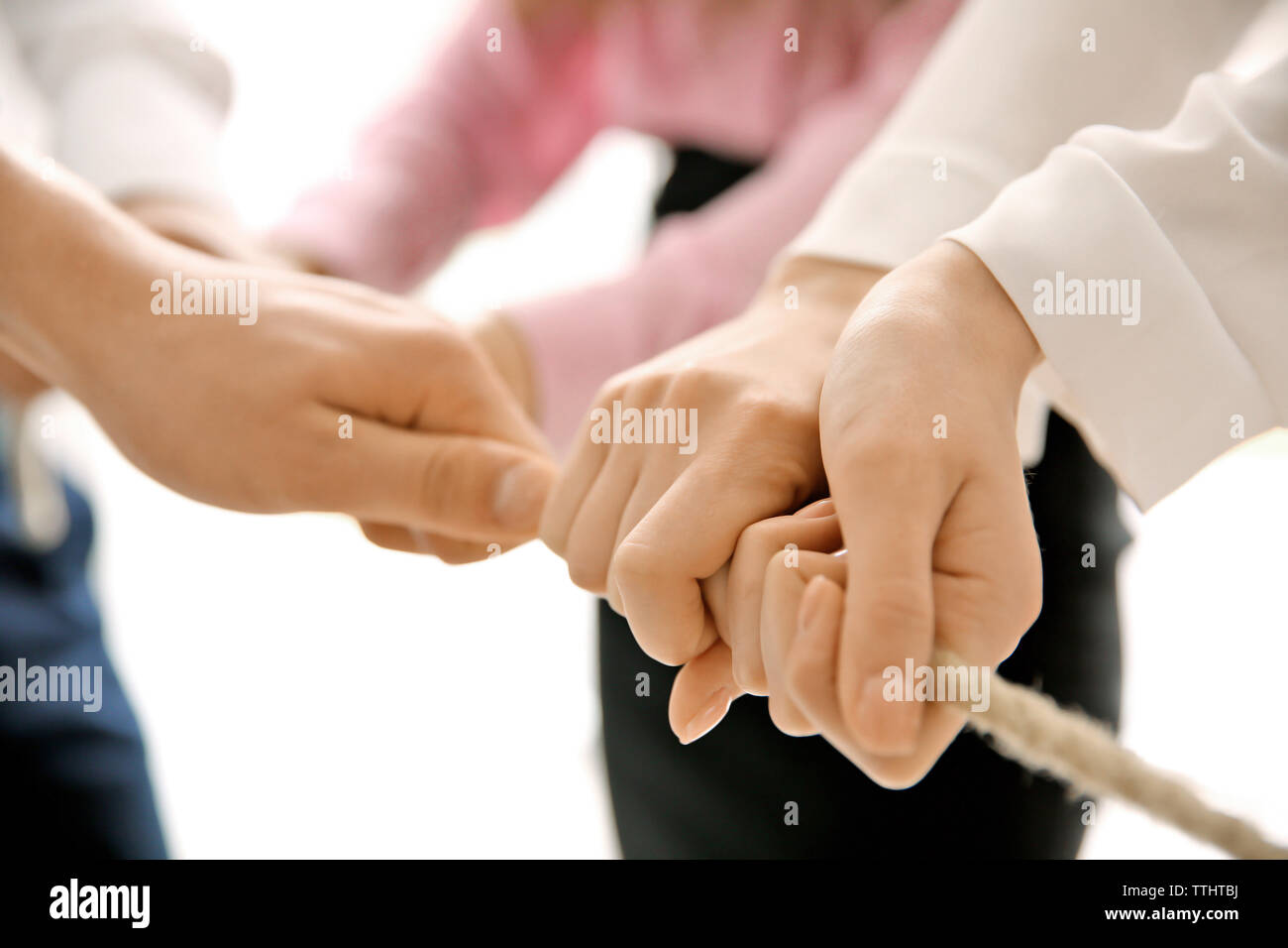 People hands pulling rope for playing tug of war closeup Stock Photo ...