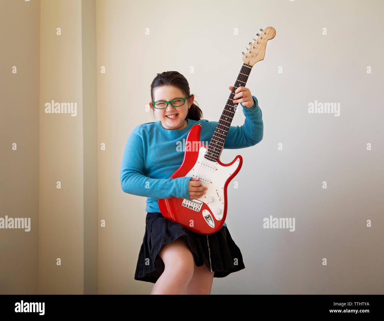 Girl standing holding electric guitar hi-res stock photography and ...