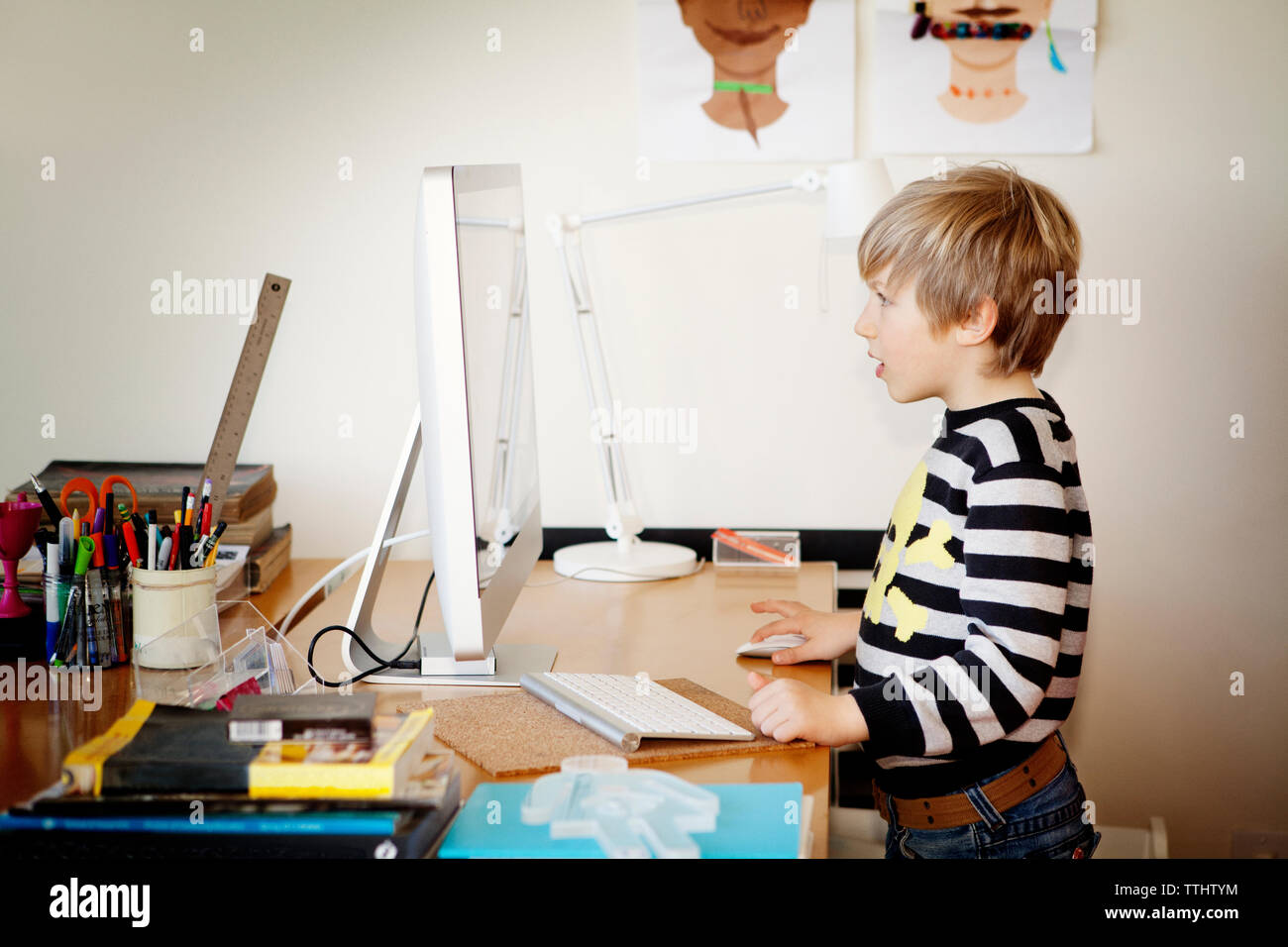 Side view of boy using desktop computer at home Stock Photo - Alamy