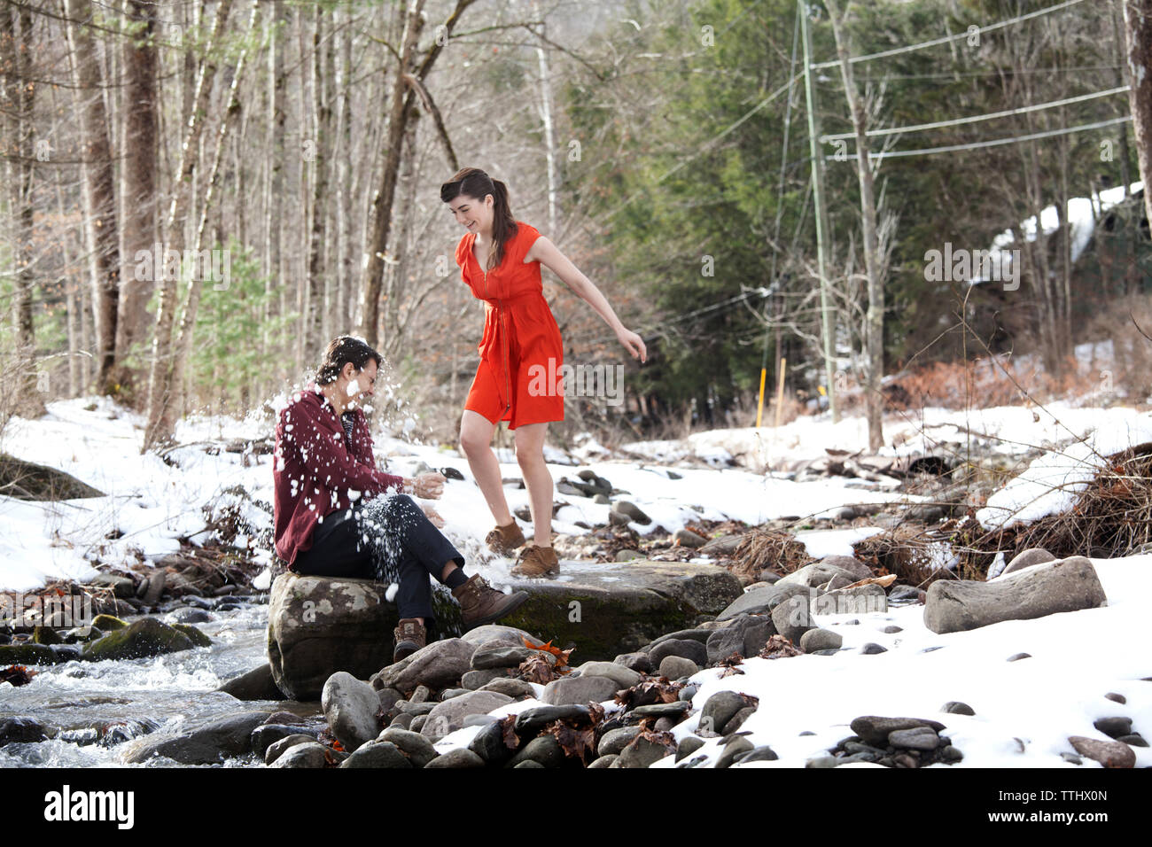 Couple playing with snow by river Stock Photo
