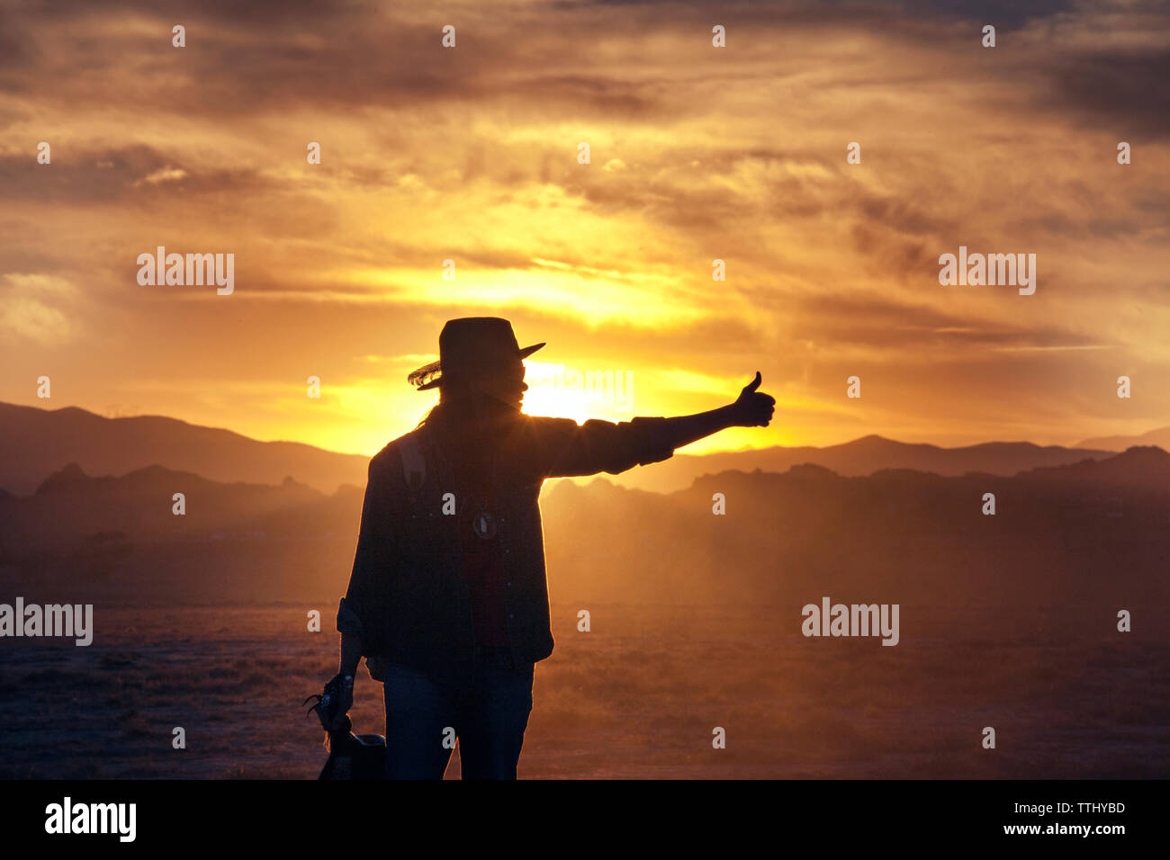 Silhouette of man showing thumb during sunset Stock Photo