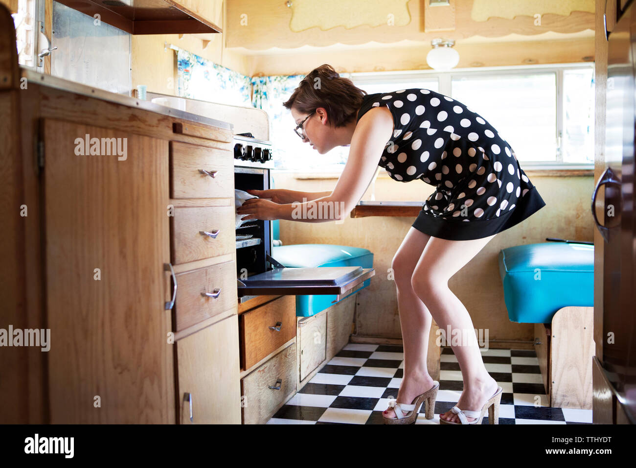 ophouden dier Opschudding Side view of woman removing food from oven in camper van Stock Photo - Alamy