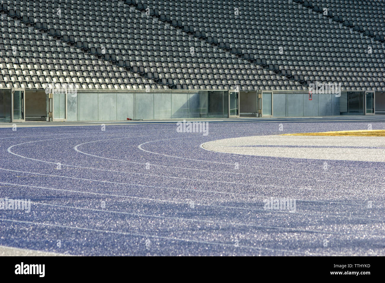 curve with wet blue tartan running track in olympic stadium berlin
