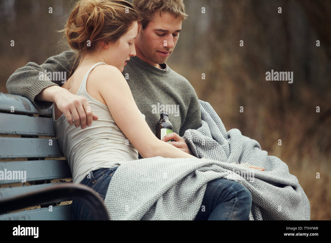 Couple looking down while sitting on bench Stock Photo