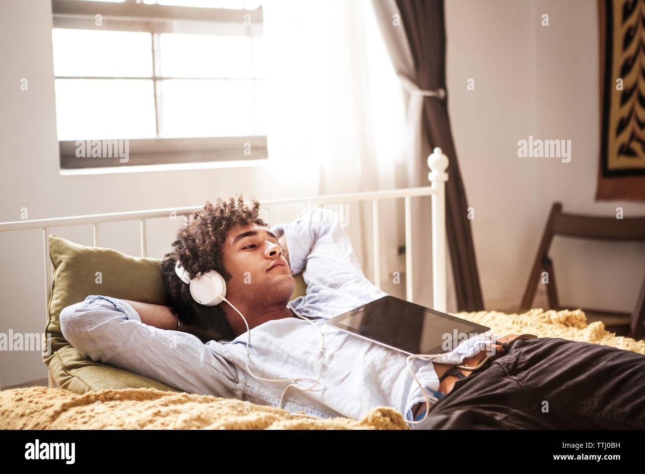 Man listening to music while relaxing on bed Stock Photo Alamy
