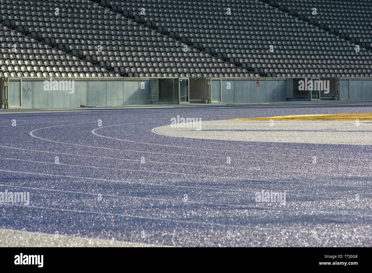 curve with wet blue tartan running track in olympic stadium berlin Stock Photo