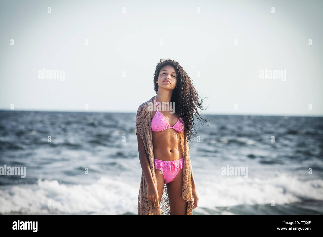 Portrait of girl in bikini standing against sea Stock Photo