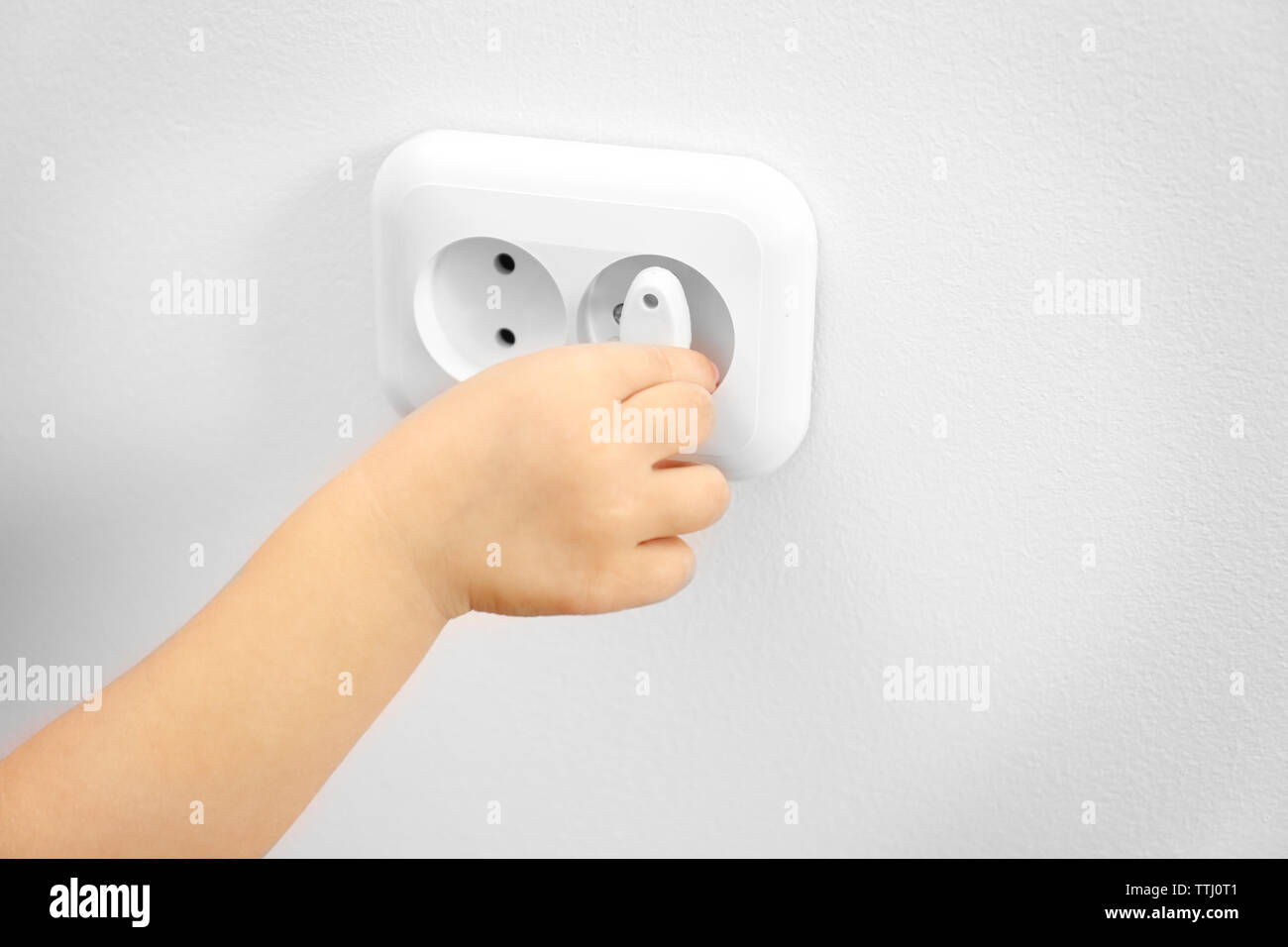 Little child putting plug in power socket Stock Photo Alamy