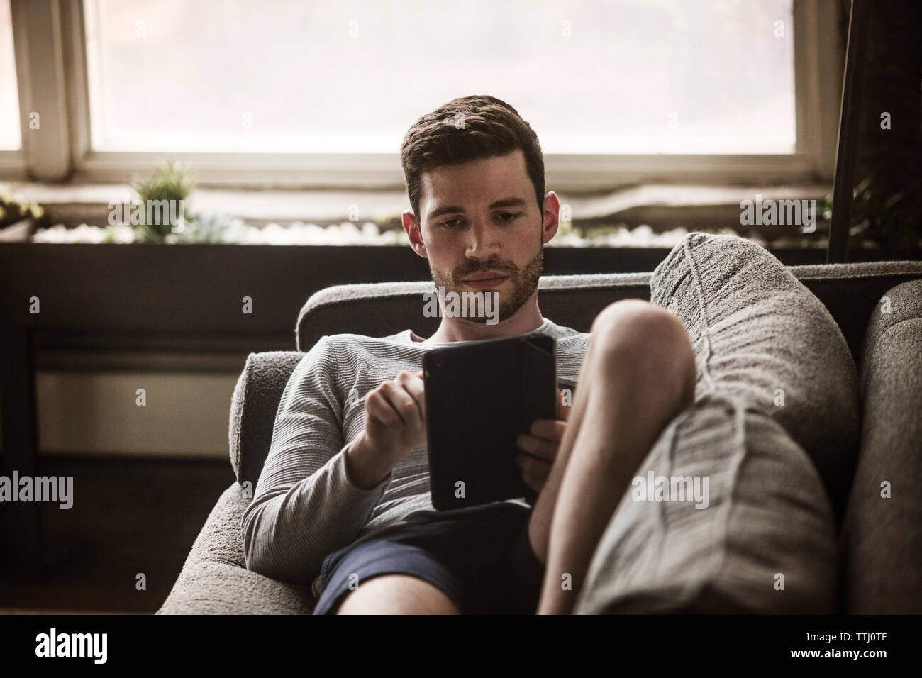 Man using tablet computer at home Stock Photo