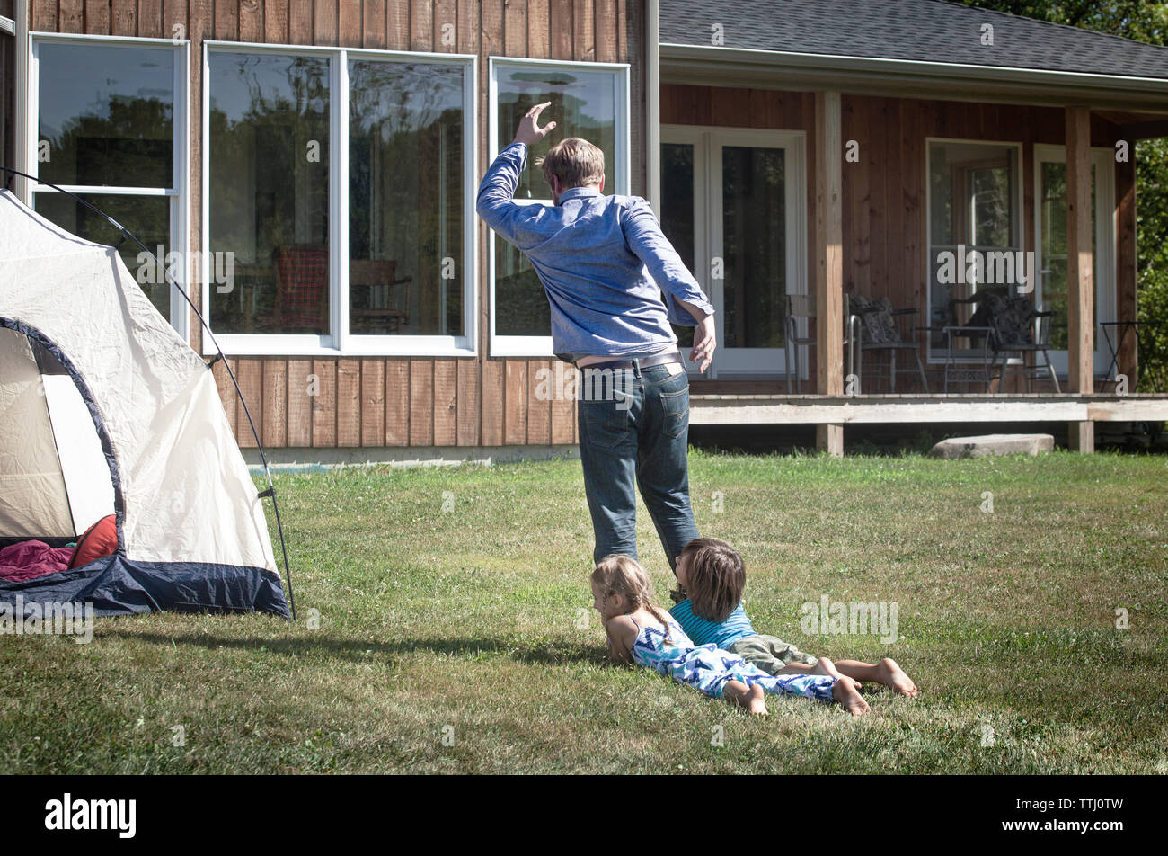 Man dragging kids while walking in lawn Stock Photo Alamy