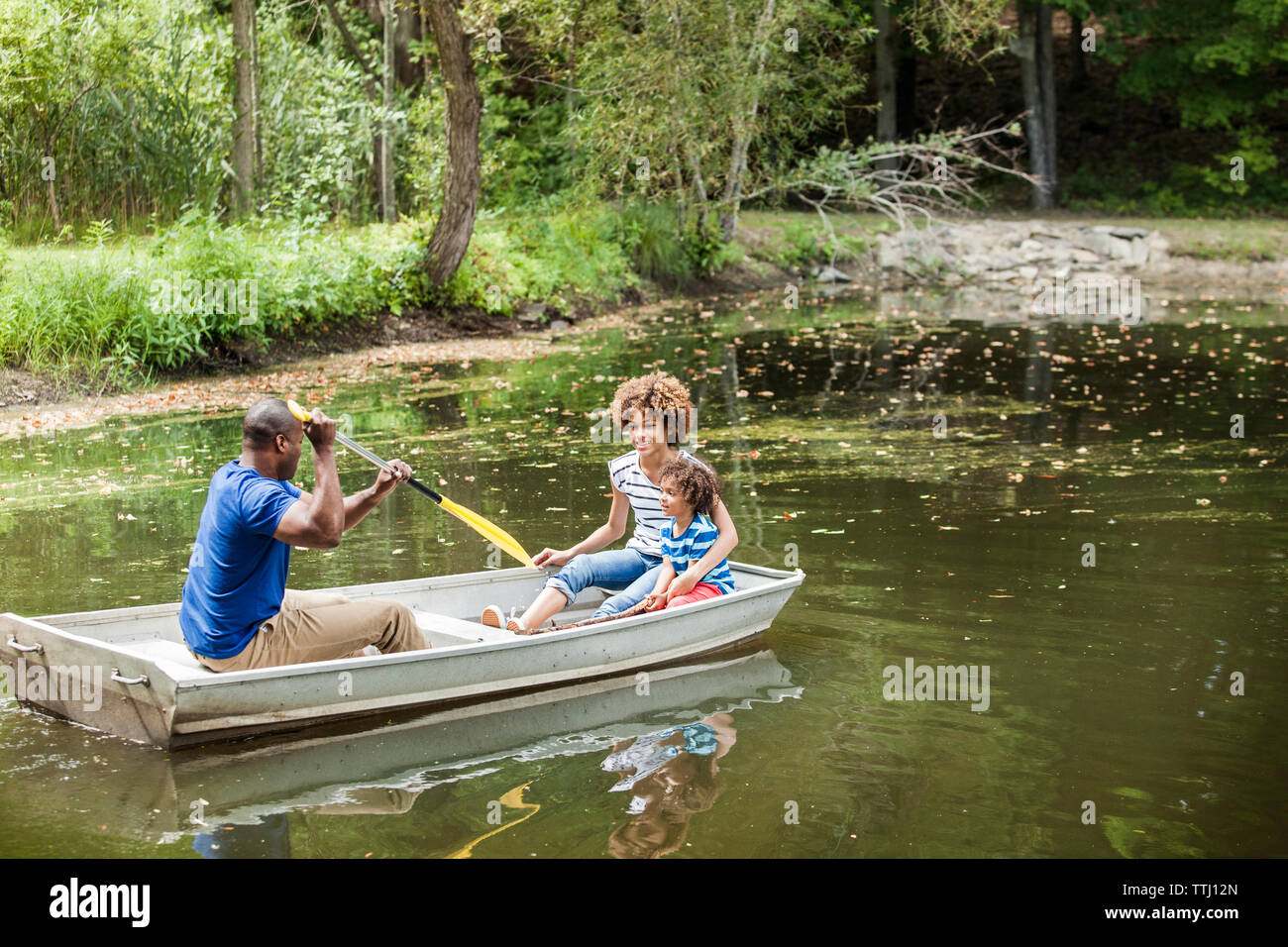 Happy family boating in lake Stock Photo