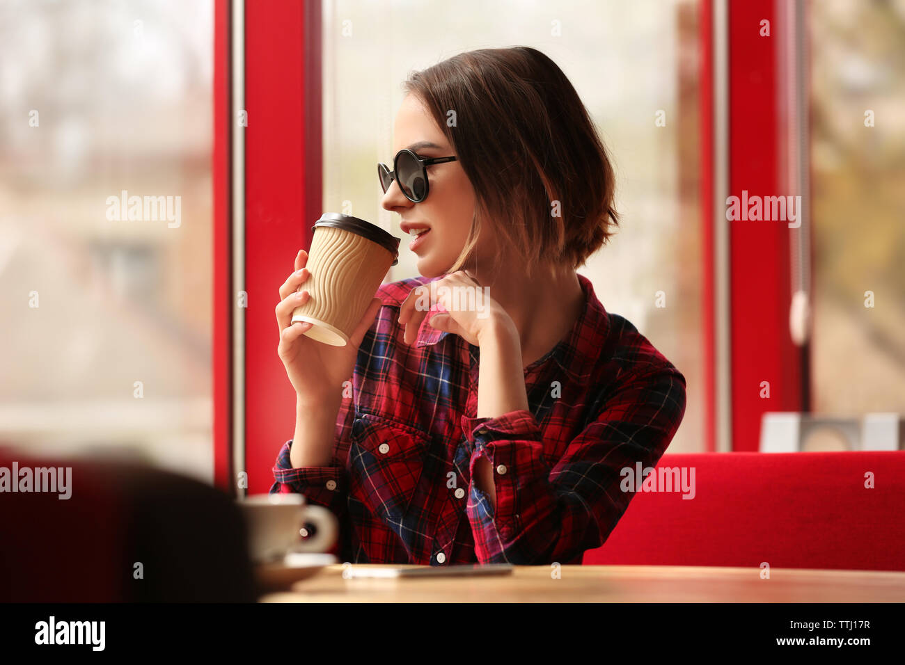 Young woman sitting in cafe Stock Photo - Alamy
