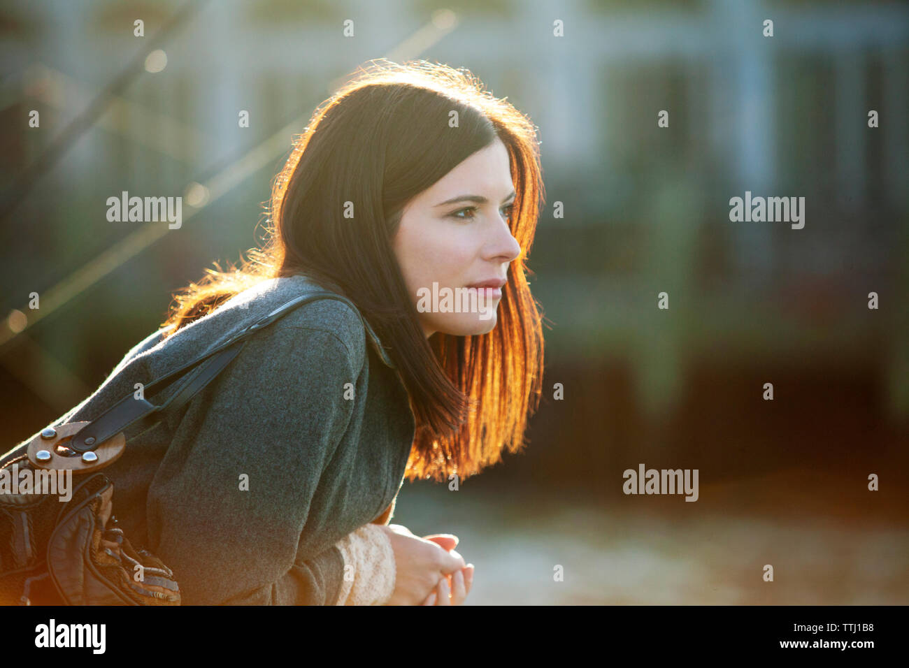 Side view of woman leaning while looking away Stock Photo