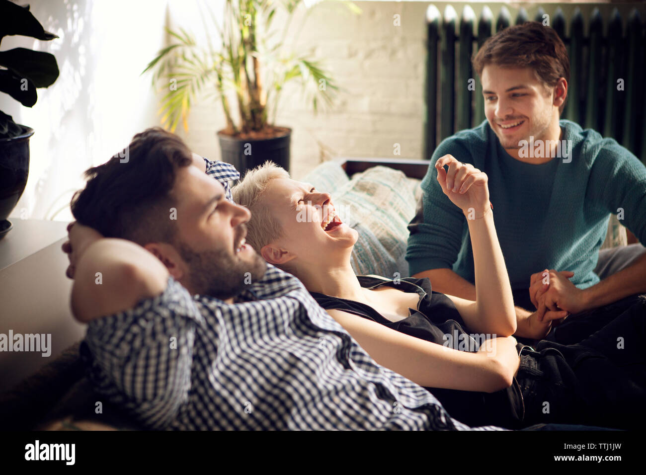 Happy friends on sofa at home Stock Photo