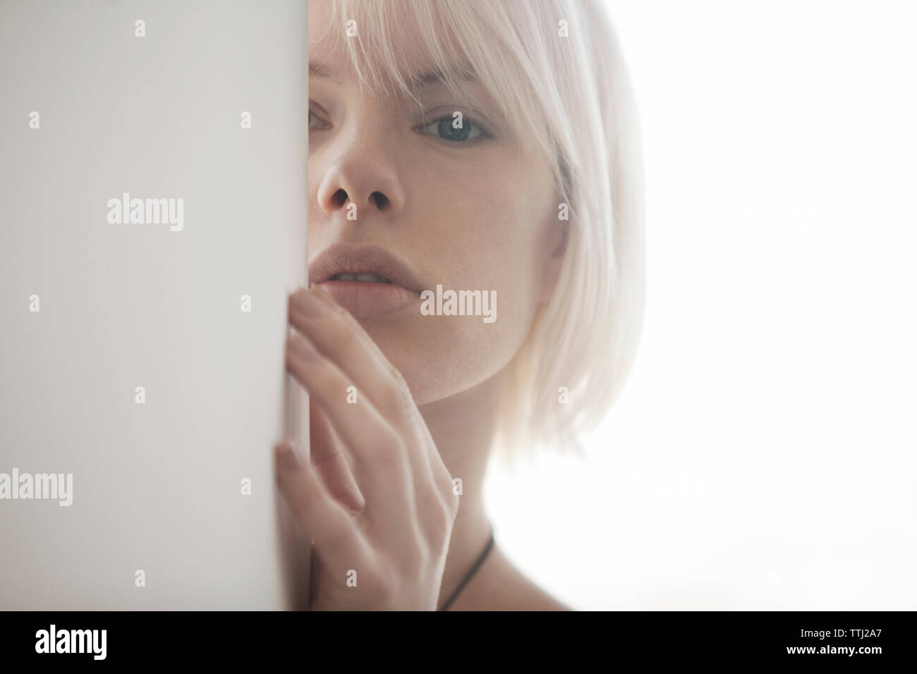 Woman hiding behind wall hires stock photography and images Alamy