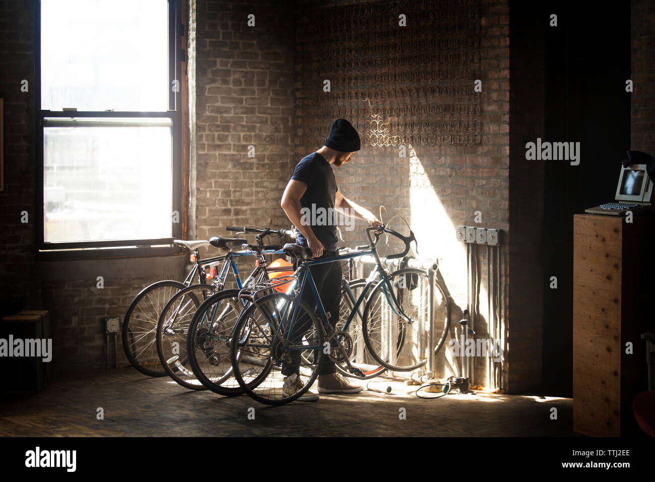 Man keeping bicycle in rack Stock Photo
