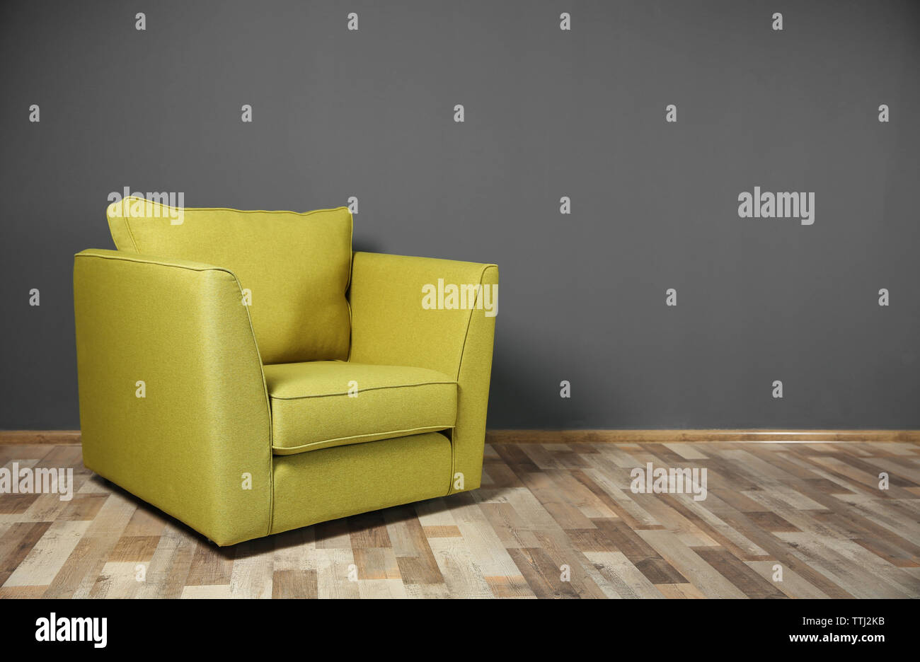 Green armchair on dark grey wall background Stock Photo Alamy