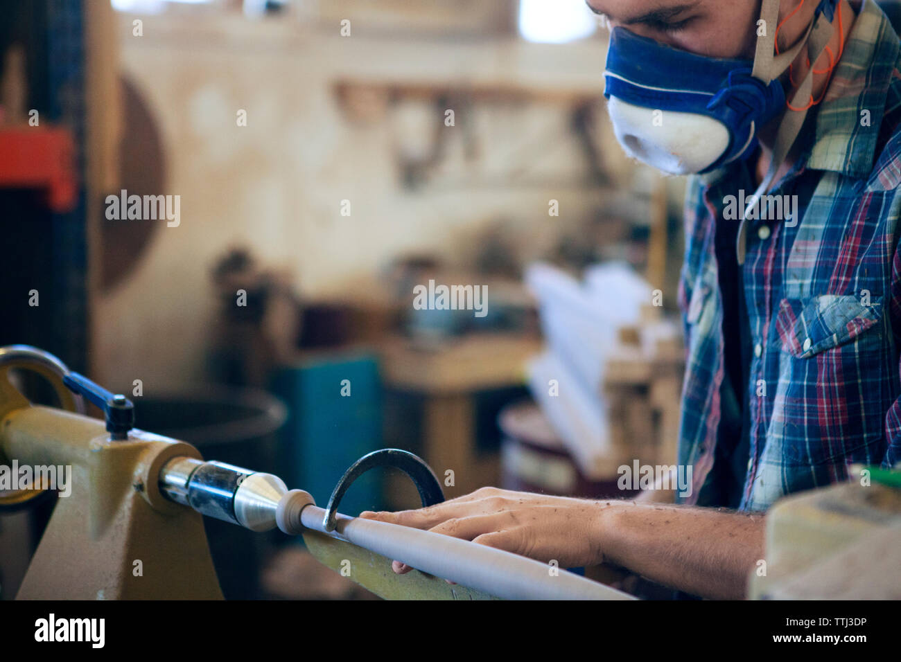 Male carpenter using handsaw in workshop Stock Photo