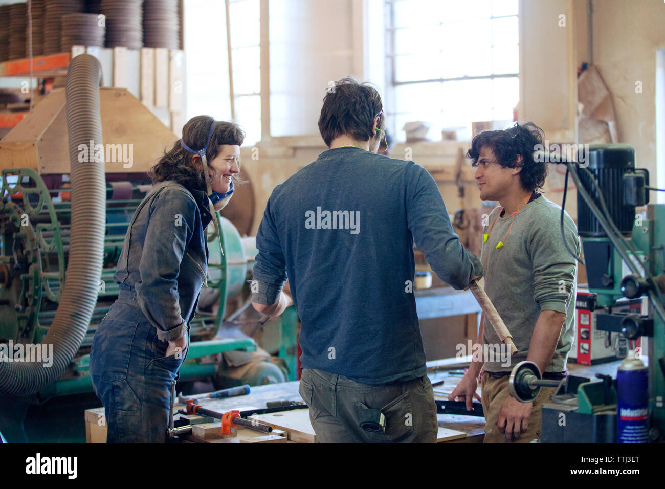 Carpenters discussing in workshop Stock Photo
