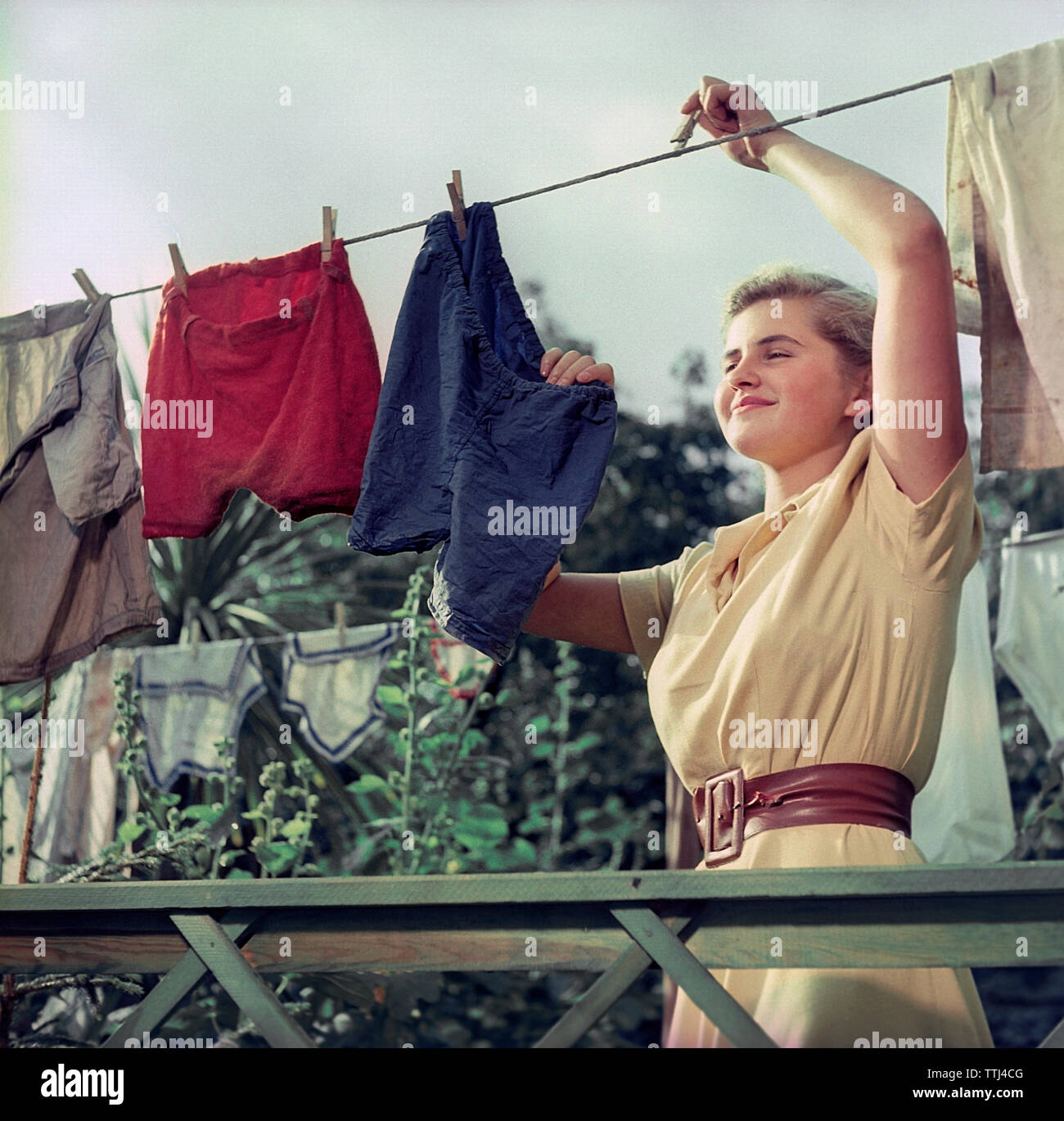 Doing the laundry in the 1950s. A young woman is hanging up the wet and clean laundry to dry. Sweden 1950s ref  BV92-9 EC232342 Stock Photo