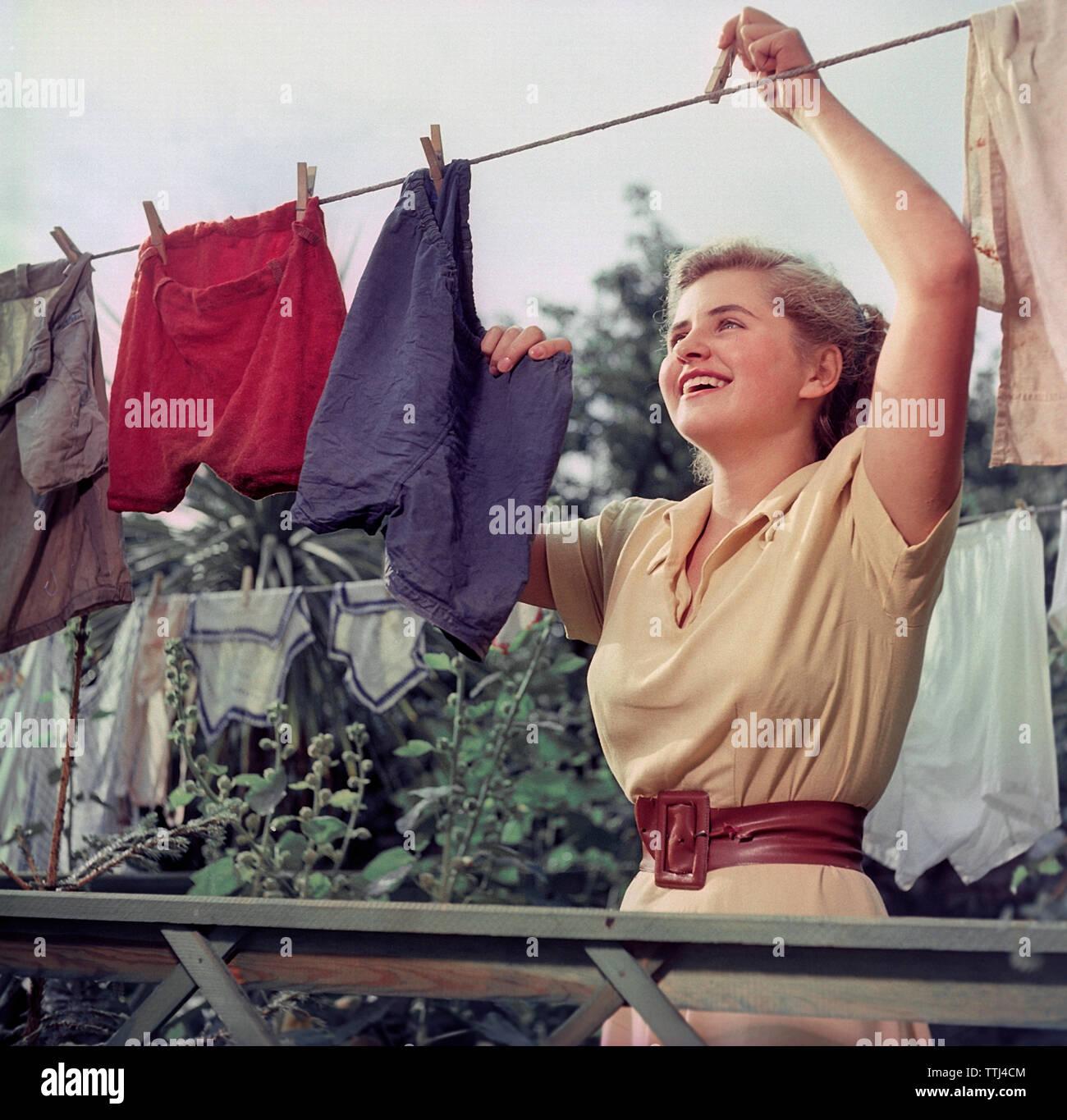 Doing the laundry in the 1950s. A young woman is hanging up the wet and clean laundry to dry. Sweden 1950s ref  BV92-10 EC232343 Stock Photo