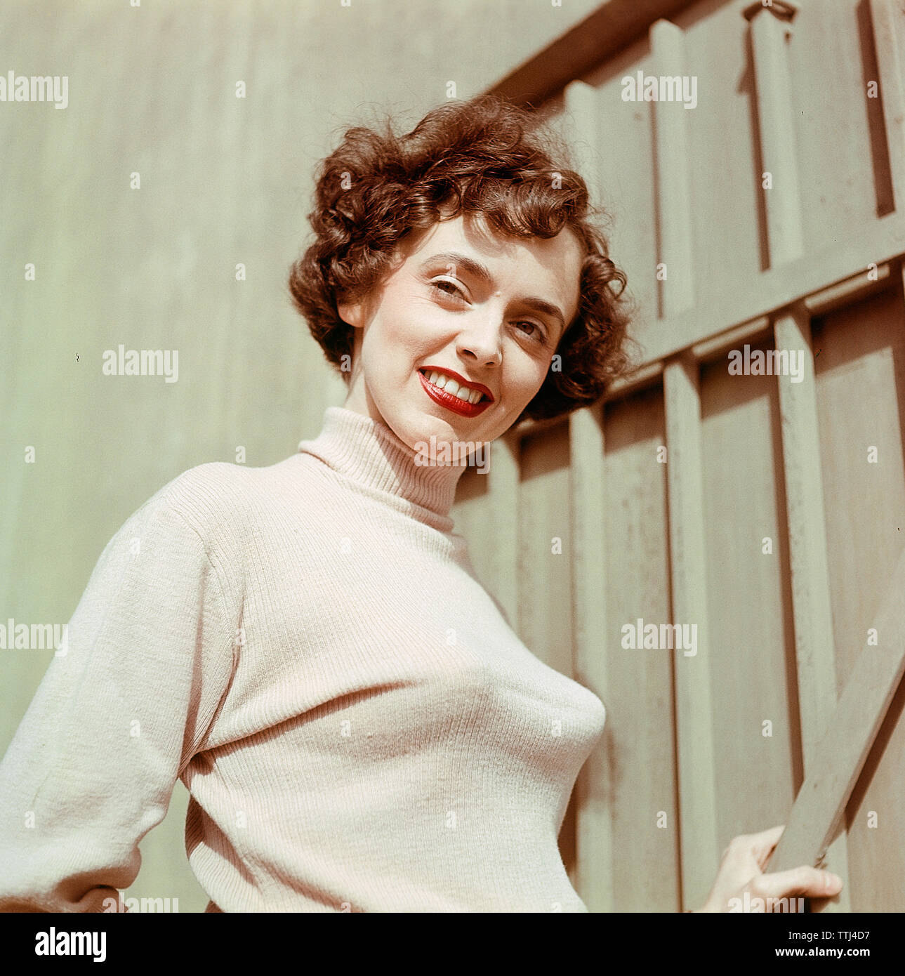 1950s jumper fashion. A swedish young woman wearing a typical 50s sweater.  Under it she is wearing a bullet bra. The popular type of bra had bra cups  in the shape of