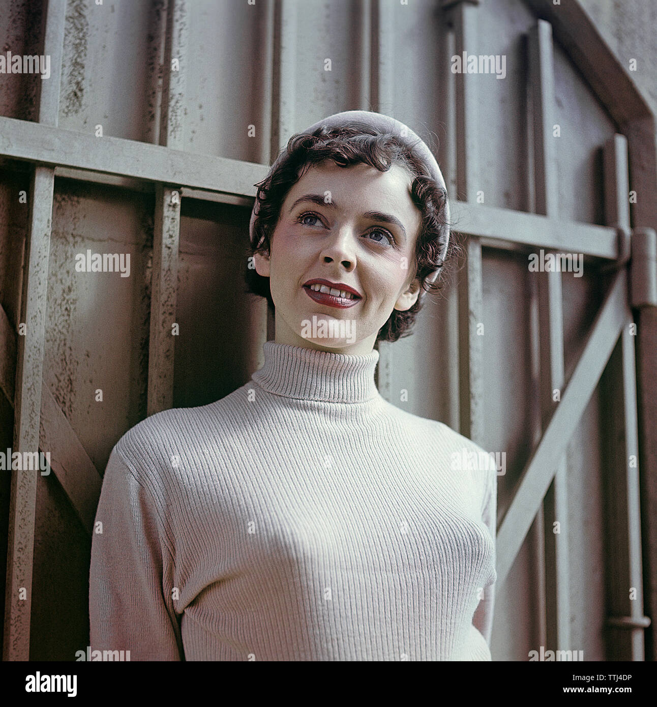 1950s jumper fashion. A swedish young woman wearing a typical 50s sweater.  Under it she is wearing a bullet bra. The popular type of bra had bra cups  in the shape of