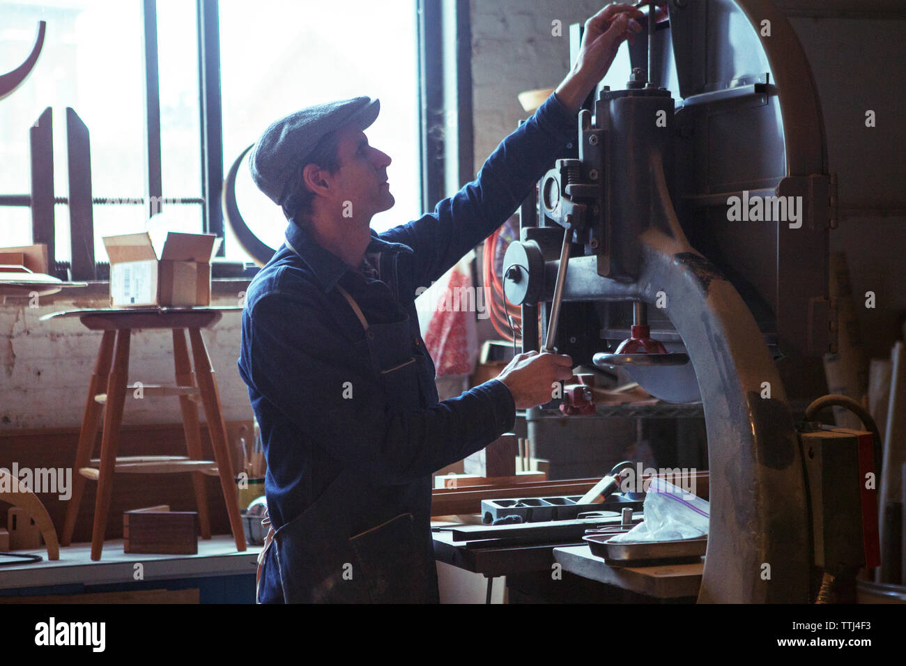 Carpenter using machinery in workshop Stock Photo
