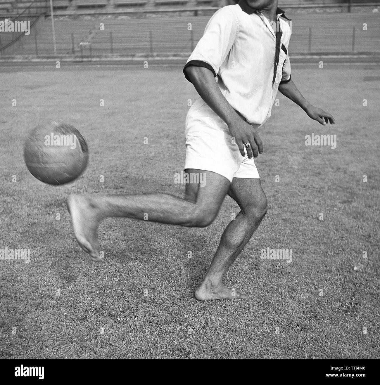 1950s soccer player. A man playing football barefoot heels the ball in the air. Sweden 1952 Kristoffersson BG39-12 Stock Photo