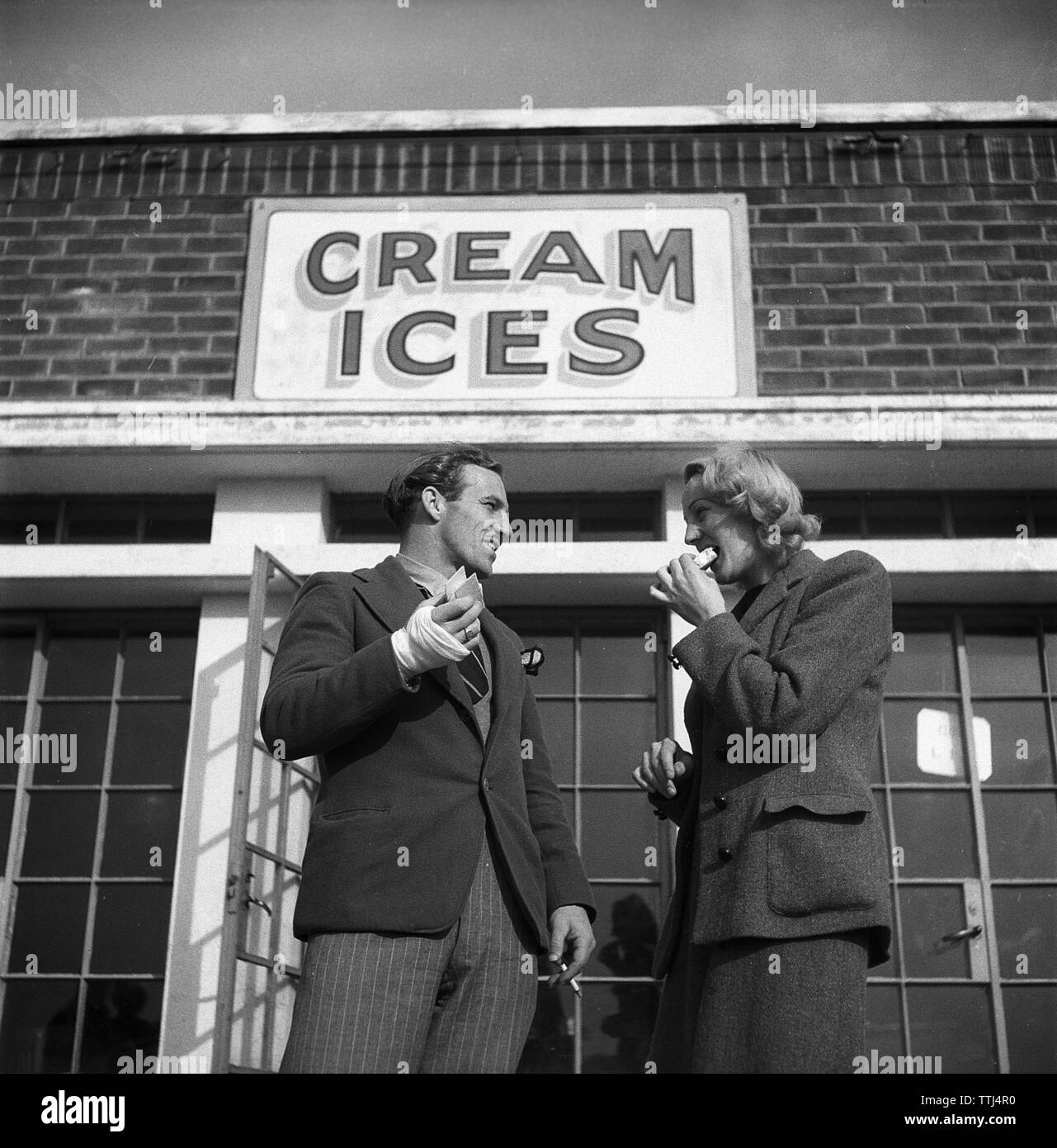 Icecream in the 1940s. A young couple in front of a ice cream shop.  UK 1945.  Kristoffersson  ref X63-4 Stock Photo