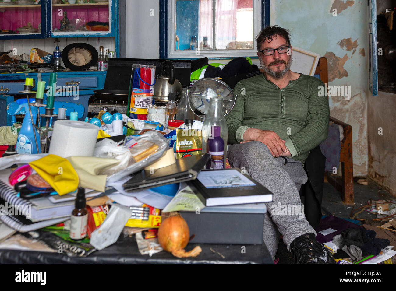 Man sitting in derelict house, County Kerry, Ireland Stock Photo