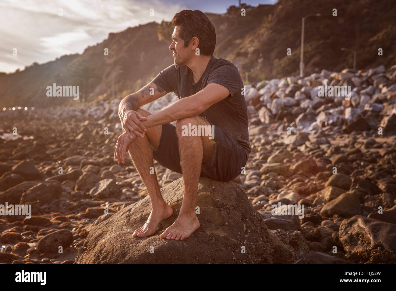 Old man sitting on rock hi-res stock photography and images - Alamy